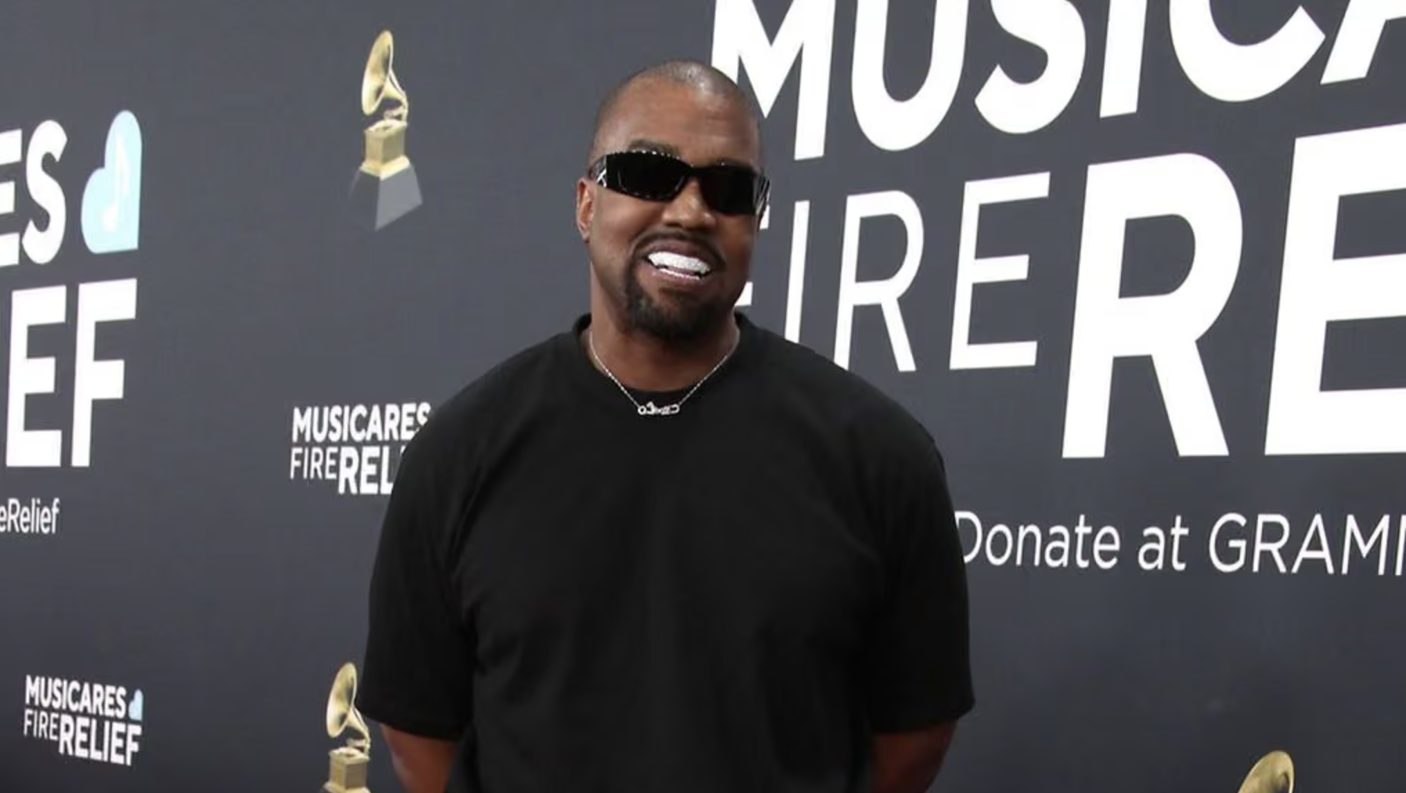Kanye West hymyilee mustissa paidassa ja aurinkolaseissa
